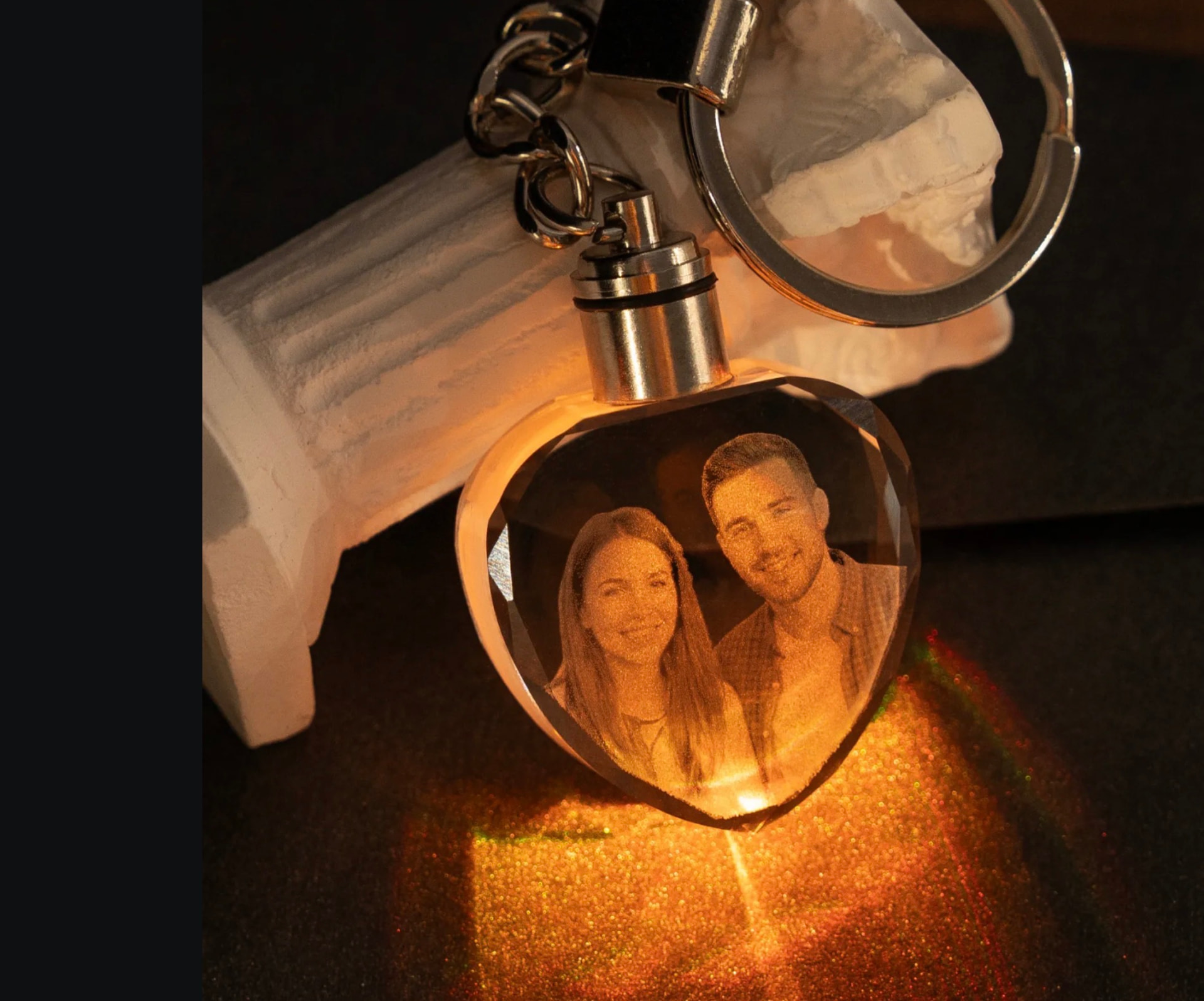Heart-shaped crystal keychain with a couple's photo engraved inside, lit from below