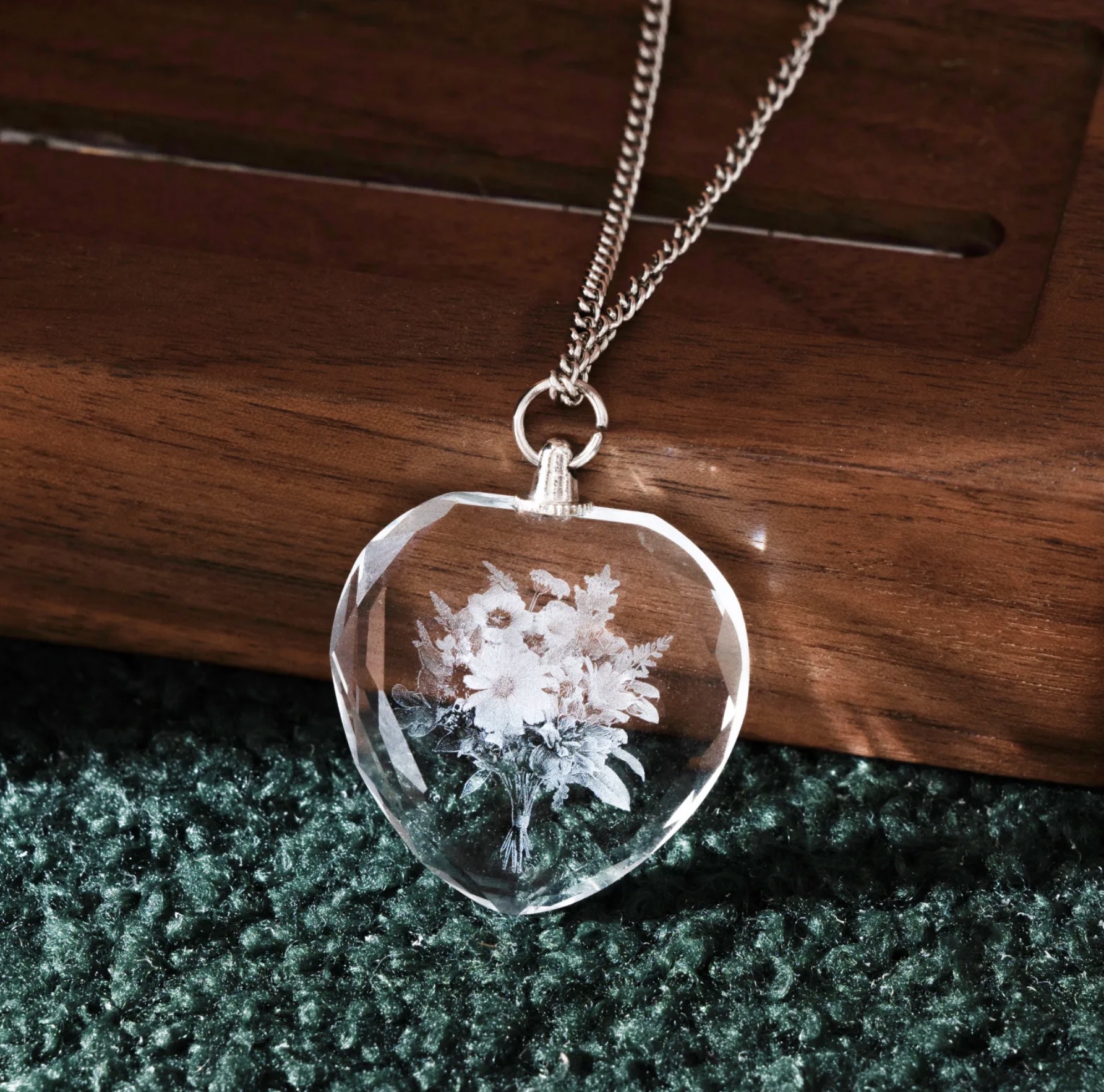 Clear crystal heart necklace with a flower bouquet engraved inside